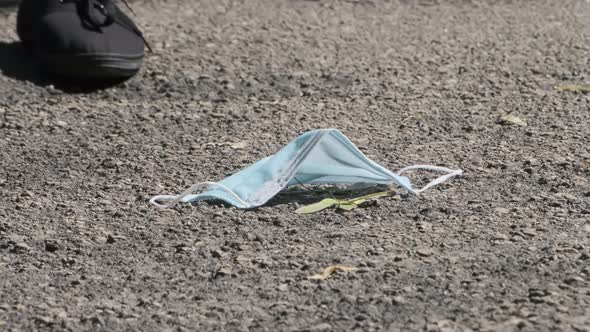 Medical mask on the floor on the street, pollution with a disposable mask,