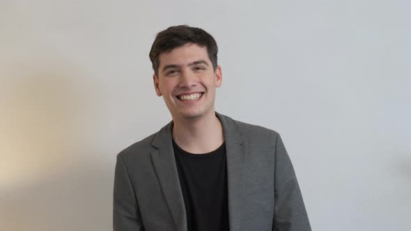 A Young Businessman Smiles and Makes Aerial Kisses alt