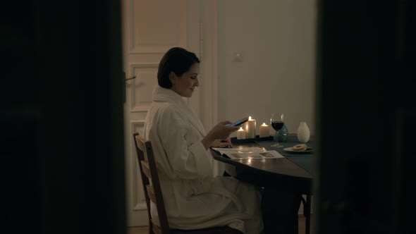 Home Cozy Concept Girl is Resting with Wine and Reading Magazine at Home alt