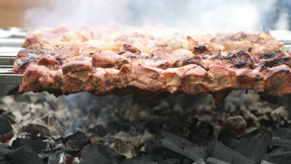 Cooking of Pig Meat on the Metal Skewers on Coals