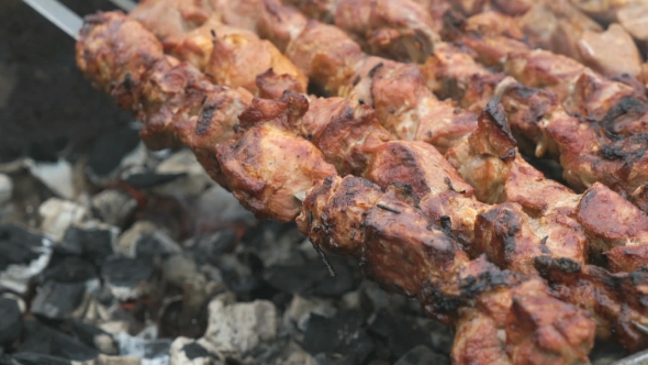 Cooking of Pig Meat on the Metal Skewers on Coals alt