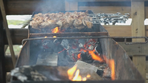 Cooking of Pig Meat on the Metal Skewers on Coals