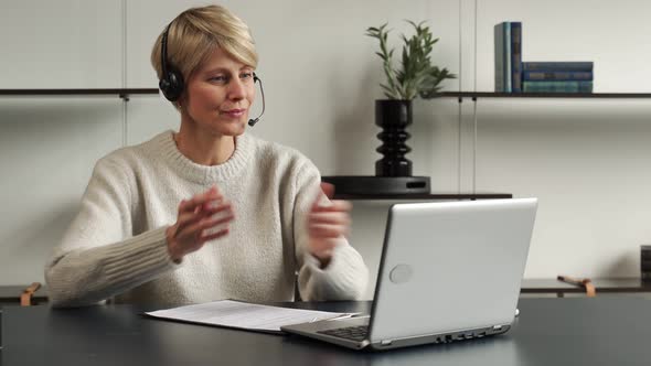 Smiling Middleaged Modern Woman Wears a Headset a Distance Course or Training on a Laptop alt