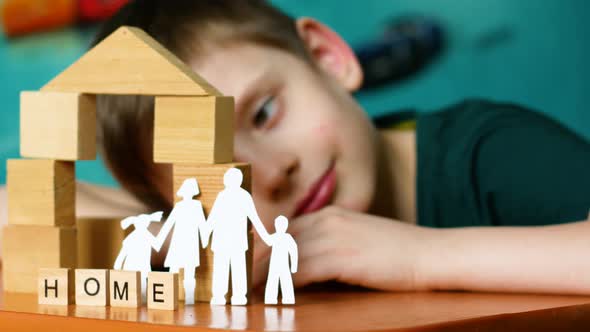 Paper carved family, house made of cubes, inscription home game and dreams of a caucasian preschoole alt