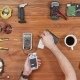 Man Repairing a Mobile Phone. Checks Parts Inside the Device. Wooden Table Top View. - VideoHive Item for Sale