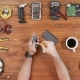 Man Repairing a Mobile Phone. Checks Parts Inside the Device. Wooden Table Top View. - VideoHive Item for Sale