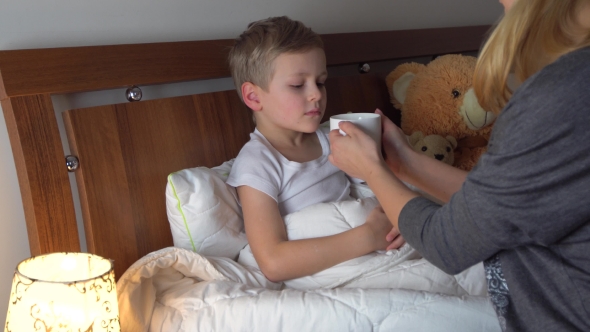 Mother Giving Medicine To Her Sick Kid