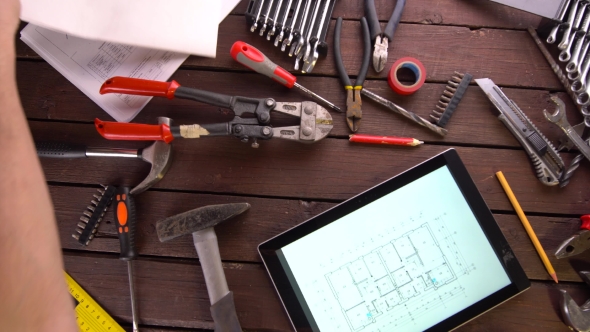 Mechanic Engineer Works with Tablet on His Desk