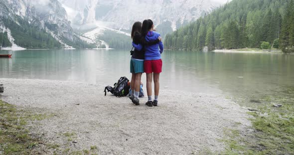 Two Women Hugs and Talk Looking Landscape View at Braies Lake