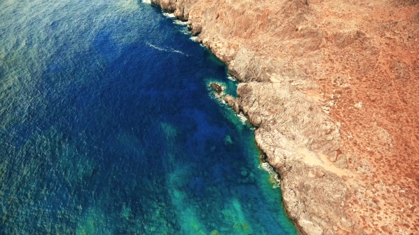 Blue Sea, Waves Breaking in Cliffs at Shore