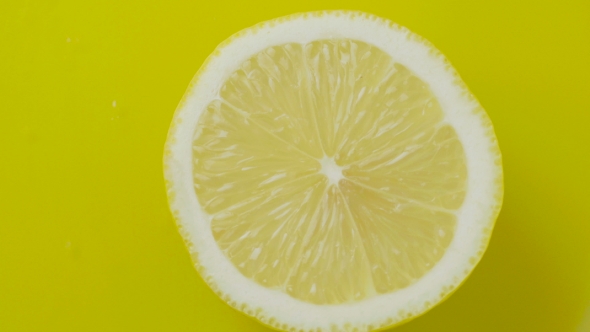 The Cut Lemon Rotating on a Yellow Background.
