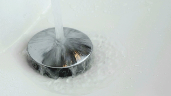 The Process of Draining Water Into the White Sink