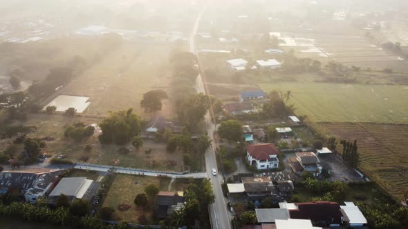 Establishing Aerial View Shot of sunrise with fog above asia village in morning