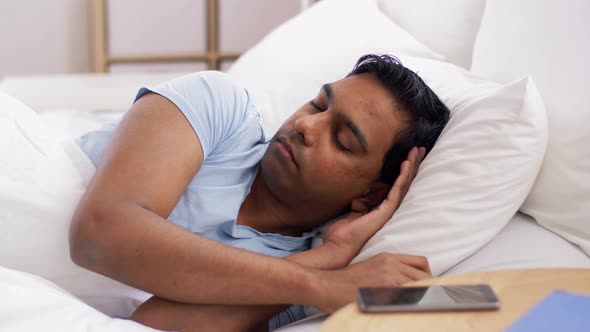 Indian Man Awaking and Stretching in Bed at Home alt