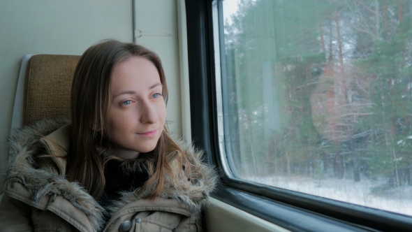 Pensive Woman Relaxing and Looking Out of a Train Window