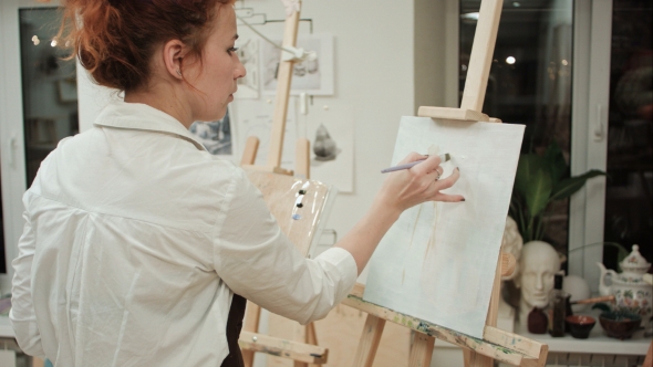 Female Painter Drawing in Art Studio Using Easel alt