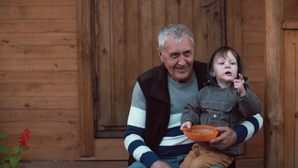 Cute Little Boy Sitting on Grandfather s Lap and Eating Berries From ...