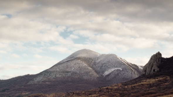 Clouds Fly Over Snowy Mountain Peak alt