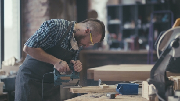 Stylish Craftsman at His Workstation. Modern Woodworker with Tattoo.
