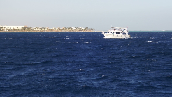 Pleasure Boat Floats on the Waves of the Red Sea on the Background of Coast and Beaches in Egypt alt