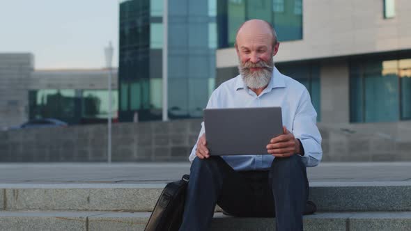 European Retired Caucasian Mature Man Communicates with Grandchildren Using Modern Gadget Elderly alt