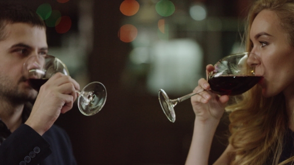 of a Couple Toasting with Red Wine in Restaurant