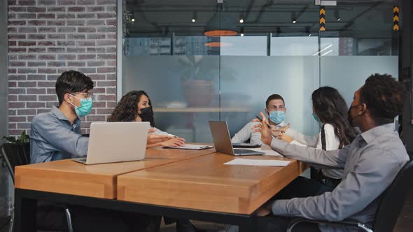 Diverse Employees in Medical Masks Quarrel Sitting in Office Angry Colleagues Arguing Group alt