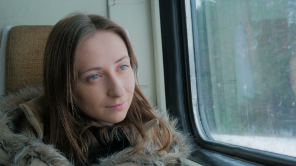 Pensive Woman Relaxing and Looking Out of a Train Window