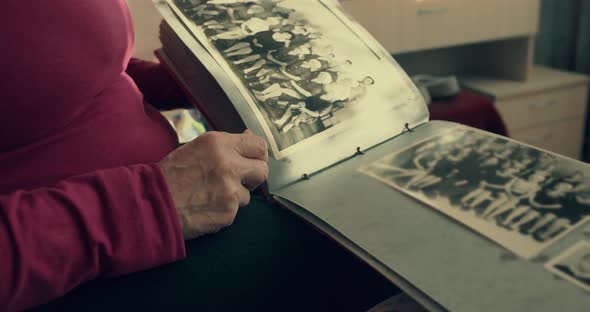 A Woman Flips Through an Old Photo Album and Remembers the Past