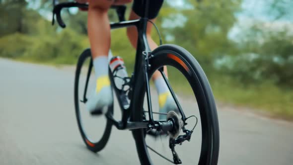 Sport Athlete Cyclist Twists Pedal Rotate Wheel On Road Bike. Cycling Triathlon Intensive Training. alt