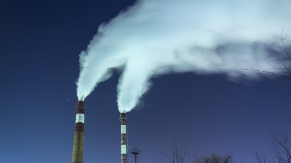 Smoking Chimneys Against the Night Sky and Stars. Air Pollution and the Environment alt
