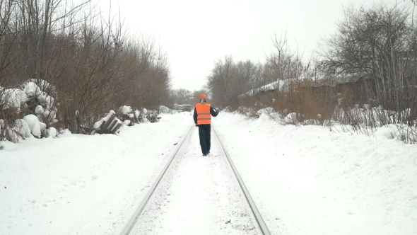 Worker with a Sledgehammer Goes Along the Railway alt
