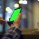 Woman Is Holding Smartphone with Green Screen in Cafe - VideoHive Item for Sale