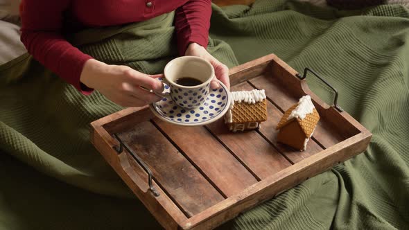 Woman drinking a coffee in a bed