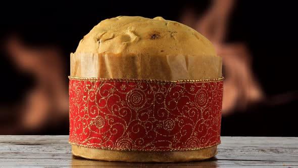 Italian panetone on wooden table fire in the background