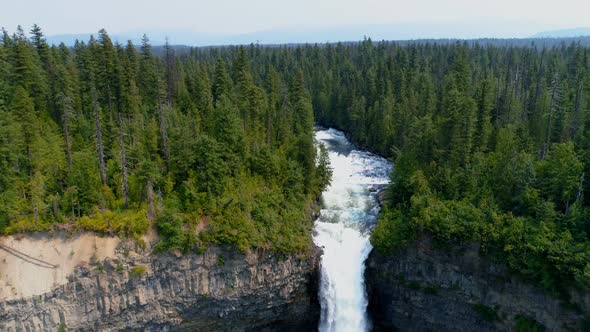 Beautiful water fall through forest cliff on a sunny day 4k alt