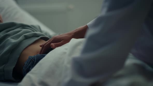 Doctor Touching Patient Stomach in Emergency Ward Closeup alt