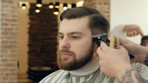 Portrait of Handsome Man with Beard in Barbershop. Barber Working with Electric Razor alt
