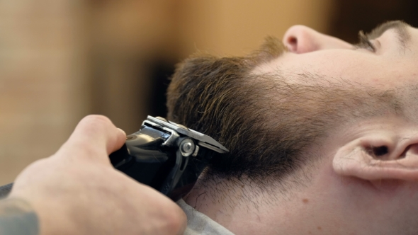 VideoHive Horizontal Portrait of a Barber Shaping Beard of His Client Using a Trimmer 19618399 VideoHive Horizontal Portrait of a Barber Shaping Beard of His Client Using a Trimmer 19618399