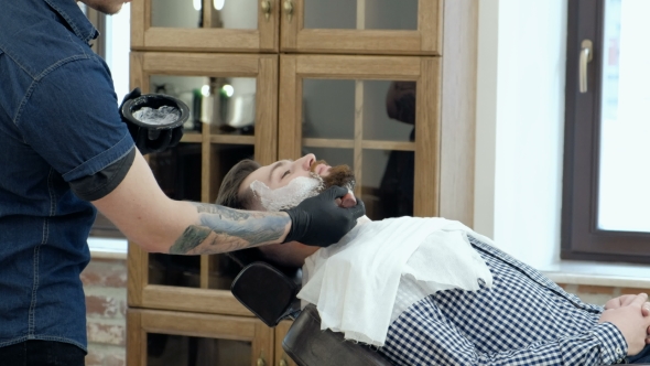 VideoHive Client During Beard Shaving in Barber Shop Barber Tattoo on His Arm 19620476 VideoHive Client During Beard Shaving in Barber Shop Barber Tattoo on His Arm 19620476