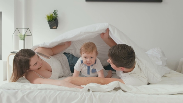 VideoHive Happy Family with Baby Boy Under Blanket on Bed 19622341 VideoHive Happy Family with Baby Boy Under Blanket on Bed 19622341