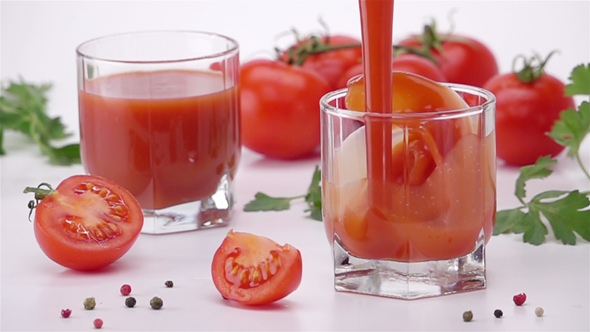Pouring Tomato Juice Into Glass. alt