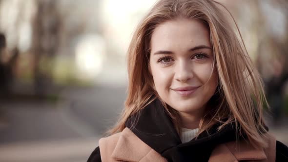 Portrait of Beautiful Female Looking on Camera with Broad Smile Spending Free Time in City Garden alt