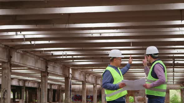 Male Engineer Talking with Worker at a Construction Site