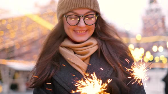 Outdoor of Young Beautiful Happy Smiling Girl Holding Sparkler, Walking on Street alt