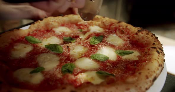 Cutting pizza with a round cutter knife. Close-up Delicious Pizza Margherita. alt