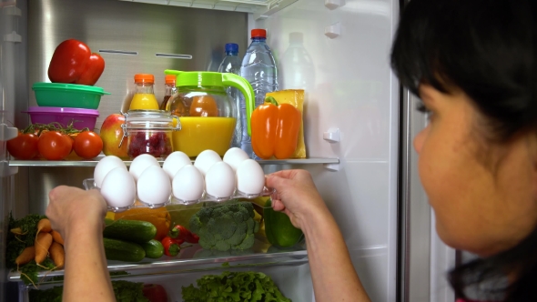 Woman Takes Eggs From Refrigerator