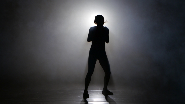 Champion Boxer in the Smoke Sends Kicks. Silhouette. Lights Rear. Black Background alt