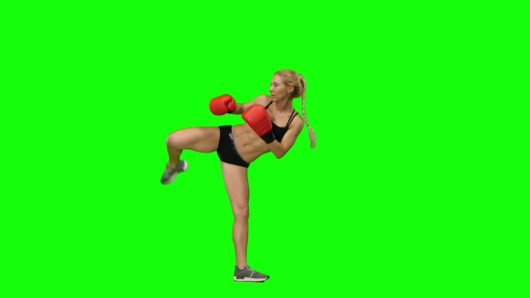 Girl Kickboxer Jumps Up and Makes Swings and Kicks. Green Screen. Side View alt