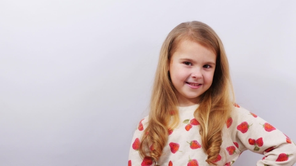 Smiling Girl Points Open Palm To the Side.